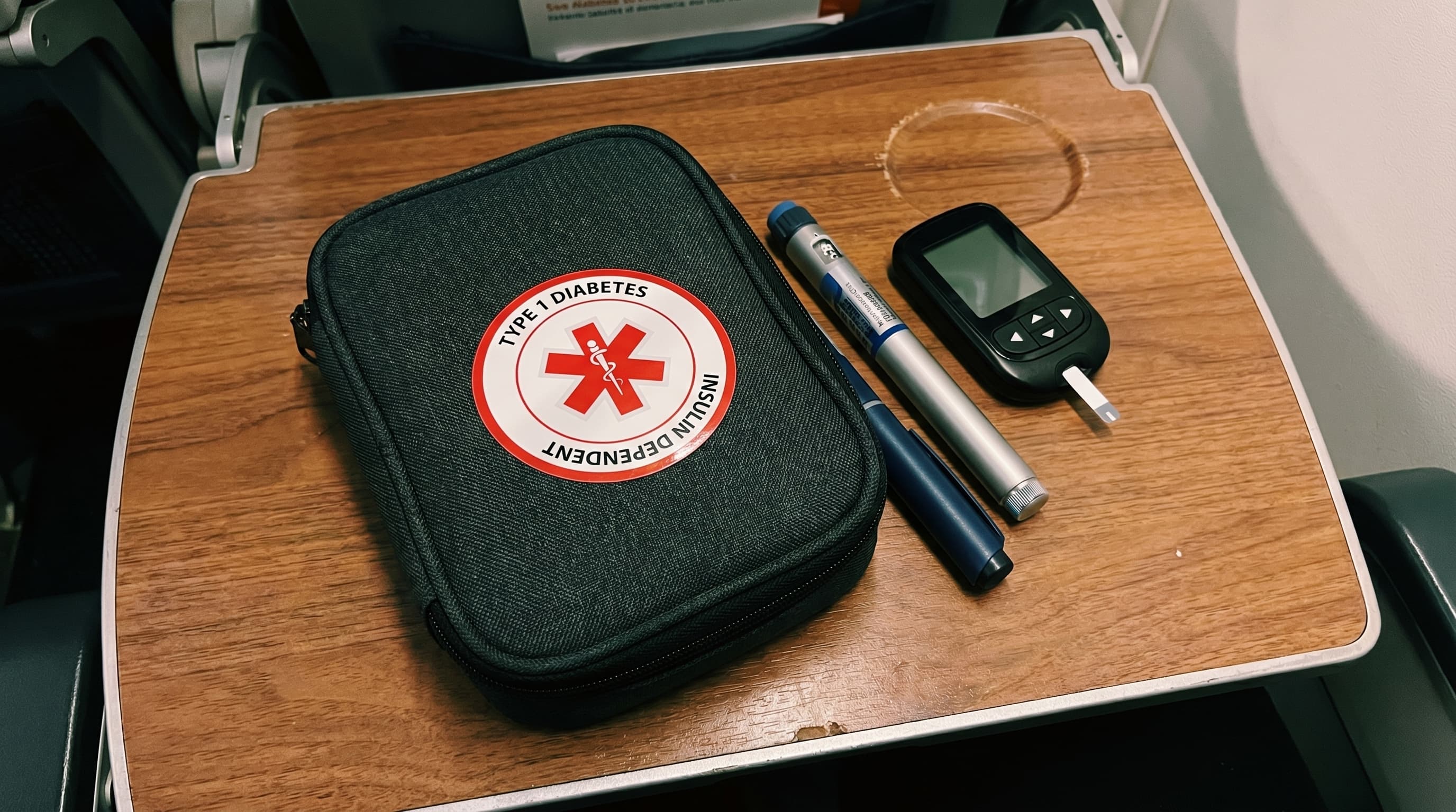 Diabetes travel kit with sticker on an airplane tray table